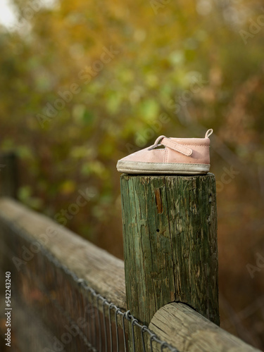 Lost Baby shoe left on a fence post to be discovered