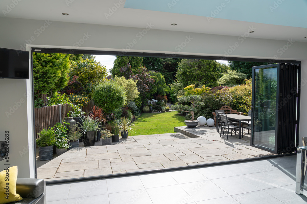 © Wormsmeat - Beautiful garden and patio in summer through bifold doors.