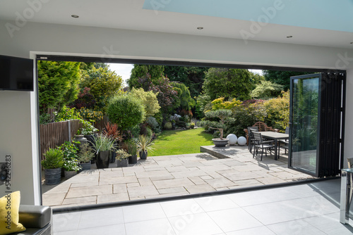 Beautiful garden and patio in summer through bifold doors.