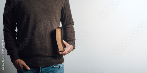 Tableau sur toile Man holding a bible in his arm. Copy space