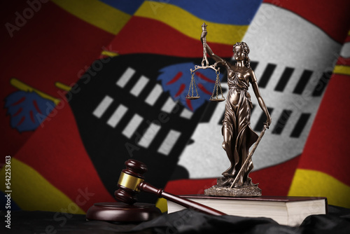 Swaziland flag with statue of lady justice, constitution and judge hammer on black drapery. Concept of judgement and guilt photo