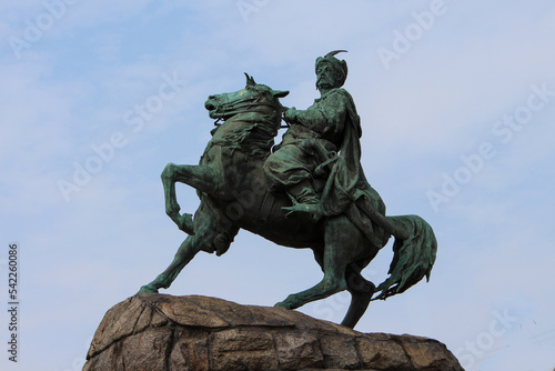 Sculpture of Hetman of Ukraine Bohdan Khmelnytskyi riding a horse against a blue sky. History of Ukraine. Bronze sculpture. A statue of an outstanding figure. Historical personality.