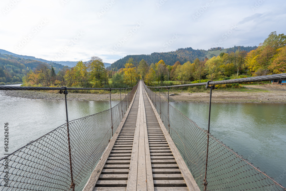rope bridge over the river in autumn