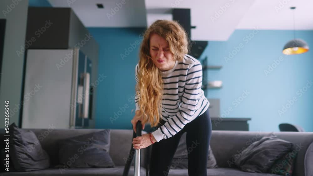 Caucasian woman has a heart attack vacuuming floor in her apartment. Adult female vacuum-cleaning the rug feels pain in her chest. Housewife cleans up the mess in the room experiences pain in heart Caucasian woman has a heart attack vacuuming floor in her apartment. Adult female vacuum-cleaning the rug feels pain in her chest. Housewife cleans up the mess in the room experiences pain in heart