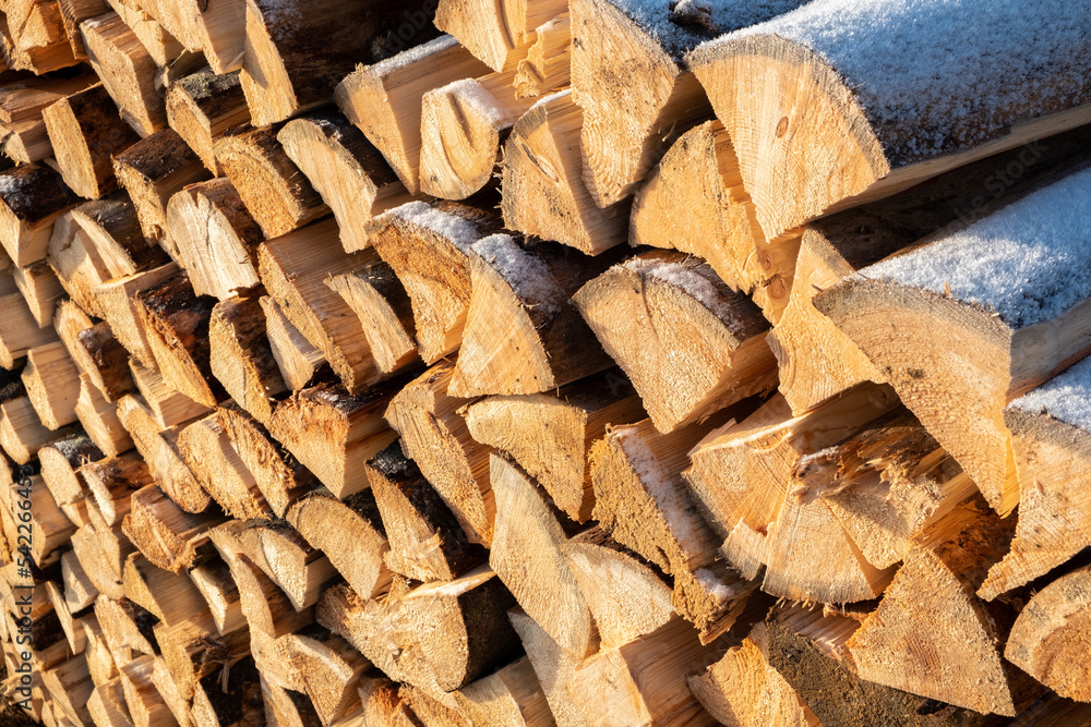 stack of snow-covered Firewood in mountains. sunny photo stack of snow-covered Firewood in mountains. sunny photo