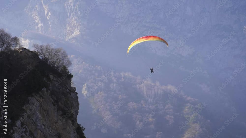 extreme paraglider flying in swiss alps, freedom concept. adventure sports video - paragliders flying over mountains on a beautiful sunny day. popular paragliding regions in Europe.