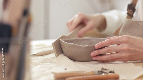 female ceramist makes clay cups in her workshop. small business, creative studio for creating ceramic tableware and masterclasses. a woman entrepreneur is doing what she loves. pottery workshop photo