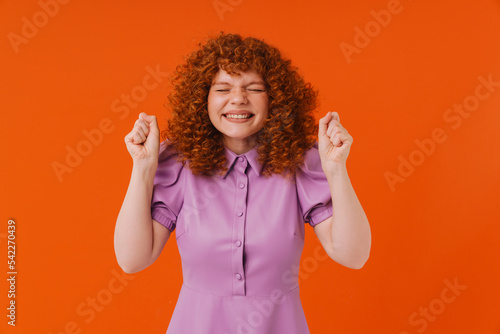 White ginger woman laughing while making winner gesture