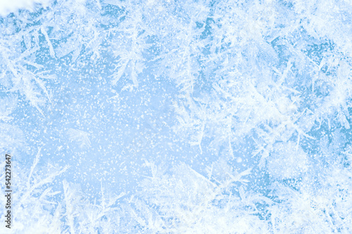 Snow-covered frost pattern on blue ice with a beautiful pattern. Background. Selective focus