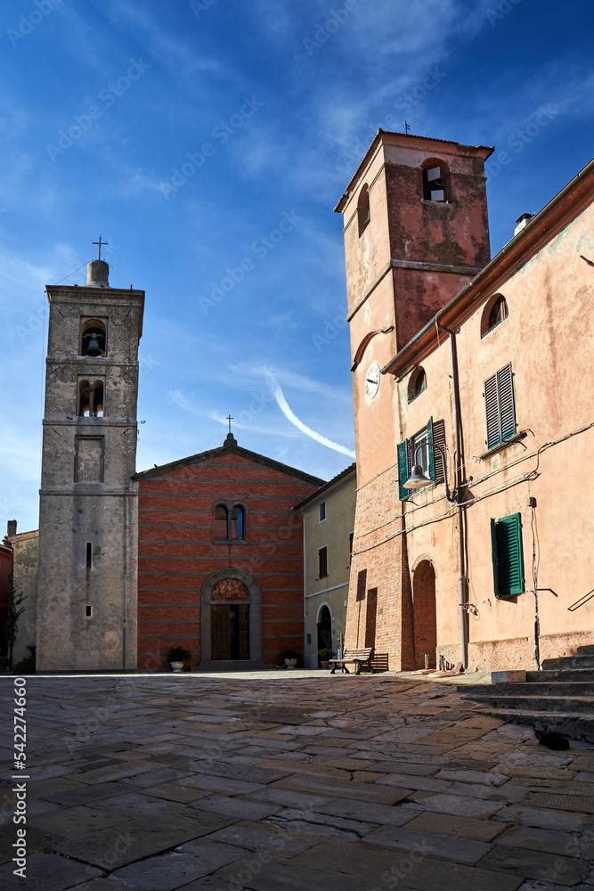 Cobbled square with stone bell towers and historic church in Montiano