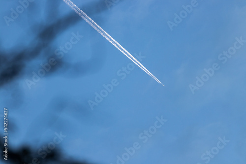 Flugzeug mit Kerosinstreifen an einem Tag mit blauem Himmel