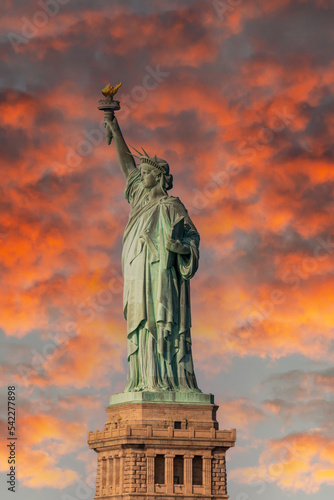 Statue of Liberty against a fiery dramatic sky with clouds