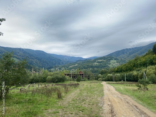Landscape with dirt road in the mountains under cloudy sky