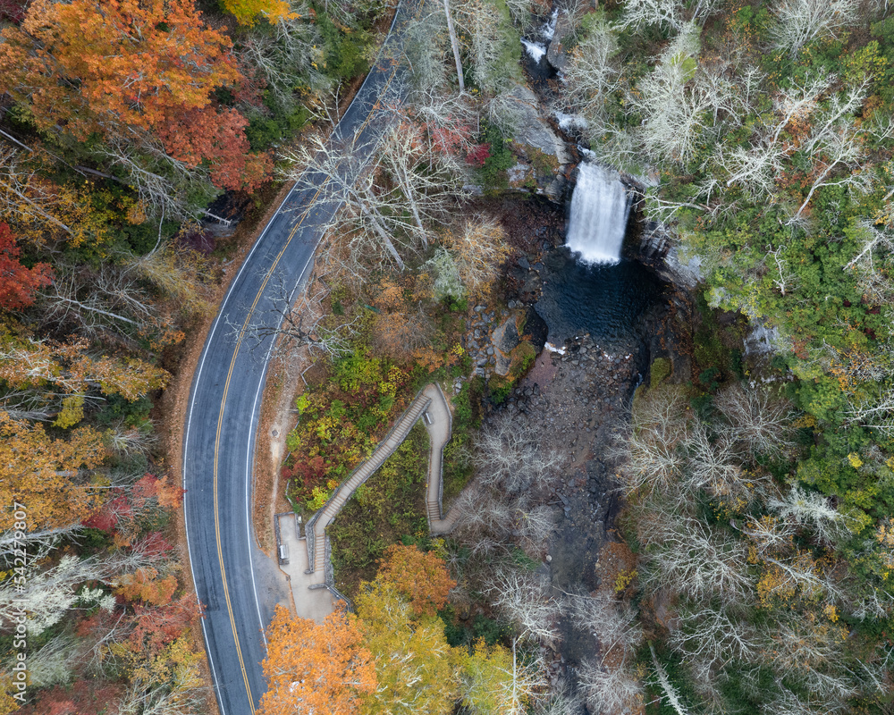 A colorful aerial view of Looking Glass Falls in autumn in Pisgah National Forest. The trees are