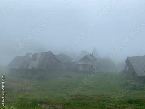 old barns for animals in the mountains, foggy weather in the carpathian mountains