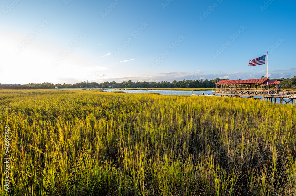 Fototapeta premium Charleston South Carolina low country marshland pier boat dock with American flag