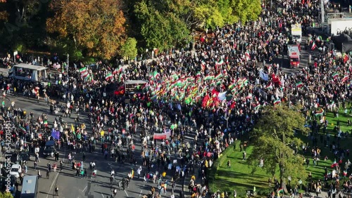 Crowd of people with Iranian flags on protest rally on square. Aerial view of Iranian demonstration. Berlin, Germany