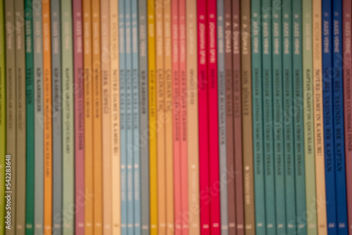 Colorful Books on Blurred Bookshelf