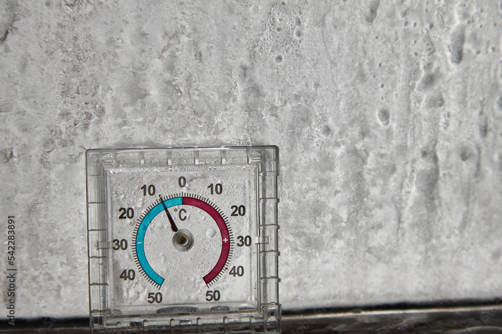 Naklejka premium thermometer with minusfrost on the glass, freezing, cooling, temperature decrease patterns on the window.