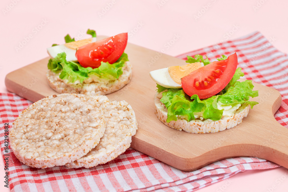 Rice Cake Sandwiches with Tomato, Lettuce and Egg on Wooden Cutting Board. Easy Breakfast. Diet Food. Quick and Healthy Sandwiches. Crispbread with Tasty Filling. Healthy Dietary Snack