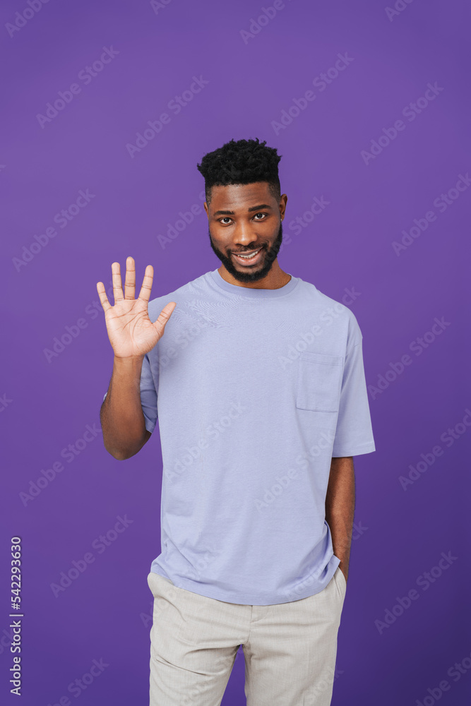 Black bearded man wearing t-shirt smiling and gesturing at camera Black bearded man wearing t-shirt smiling and gesturing at camera