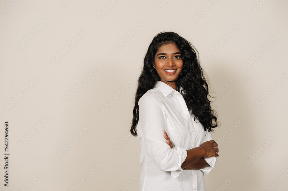 Young indian woman smiling at camera and standing with arms folded Young indian woman smiling at camera and standing with arms folded