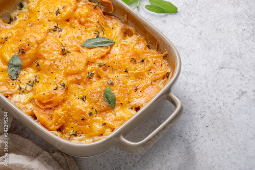 Savory Sweet potato gratin with cream and cheddar cheese in baking dish