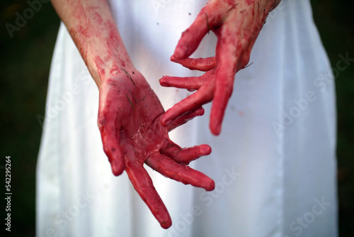 Halloween, bloody hands in front of the white woman dress