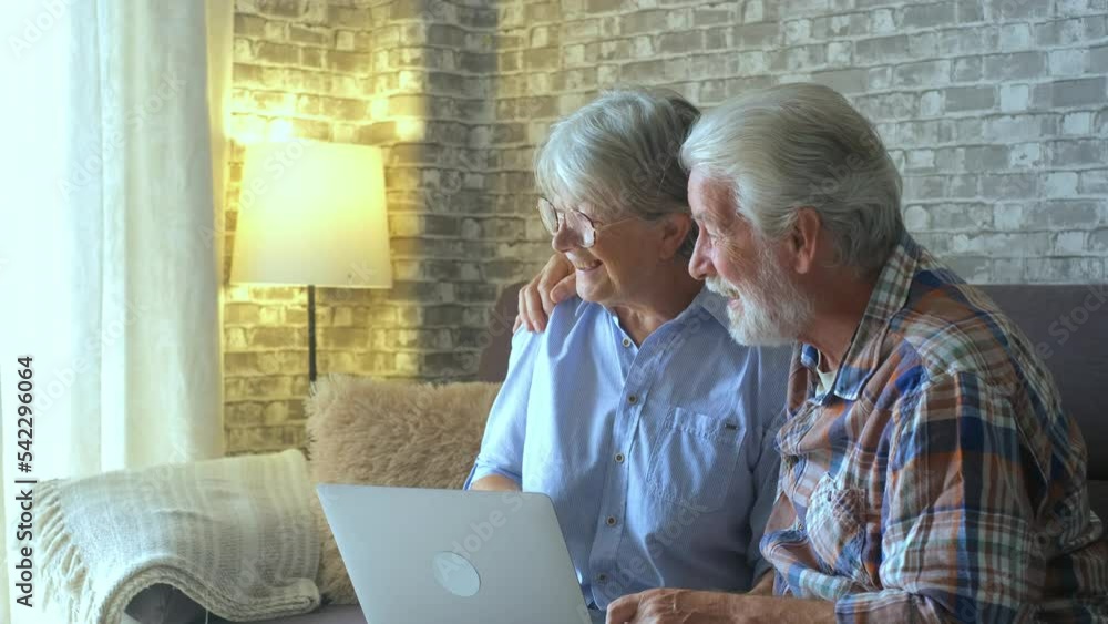 Couple of two cute seniors buying on internet on online stores and looking outdoor waiting delivery man to receive their package.