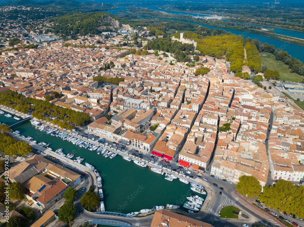 Aerial view from drone of channel with boats and historic center of Beaucaire, France