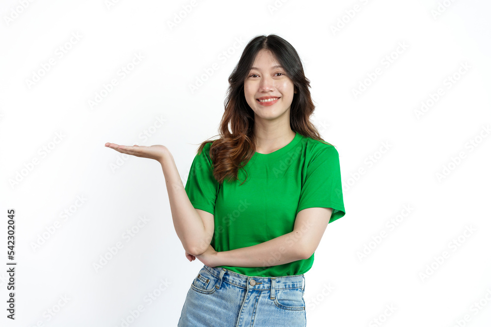 Beautiful confident Asian woman in green empty t-shirt isolated on white background. palm up to introduce a product or service Beautiful confident Asian woman in green empty t-shirt isolated on white background. palm up to introduce a product or service