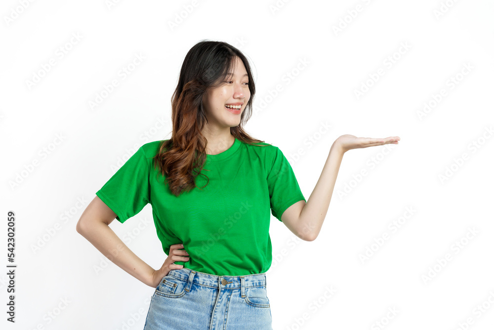 Beautiful confident Asian woman in green empty t-shirt isolated on white background. palm up to introduce a product or service Beautiful confident Asian woman in green empty t-shirt isolated on white background. palm up to introduce a product or service