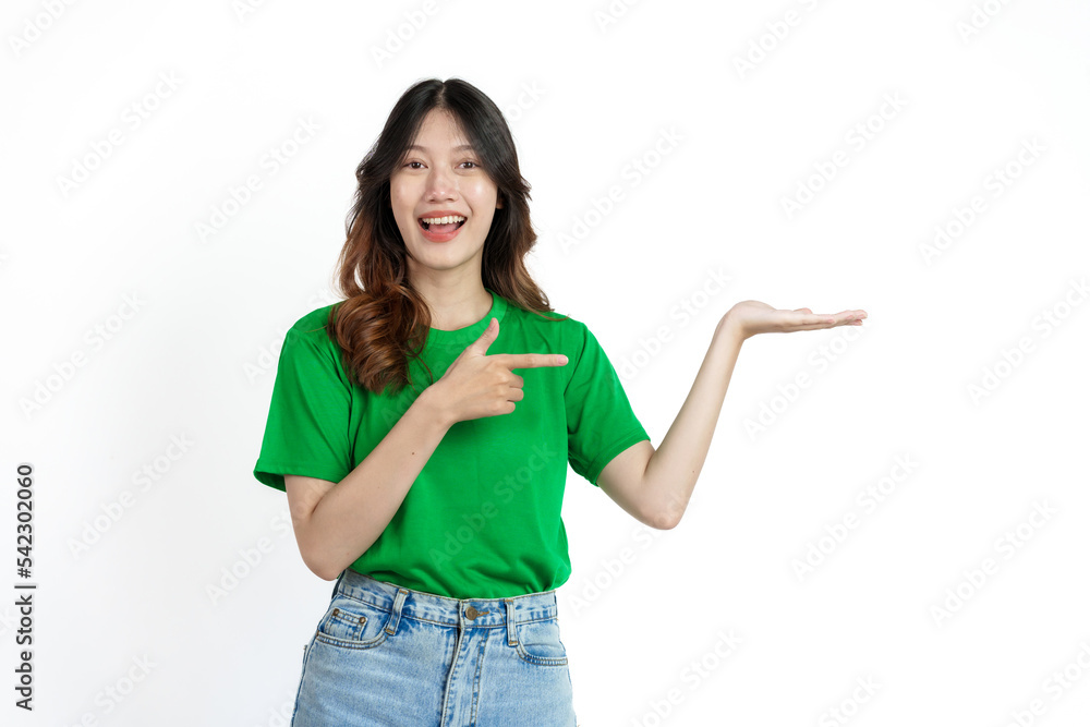 Beautiful confident Asian woman in green empty t-shirt isolated on white background. palm up to introduce a product or service Beautiful confident Asian woman in green empty t-shirt isolated on white background. palm up to introduce a product or service