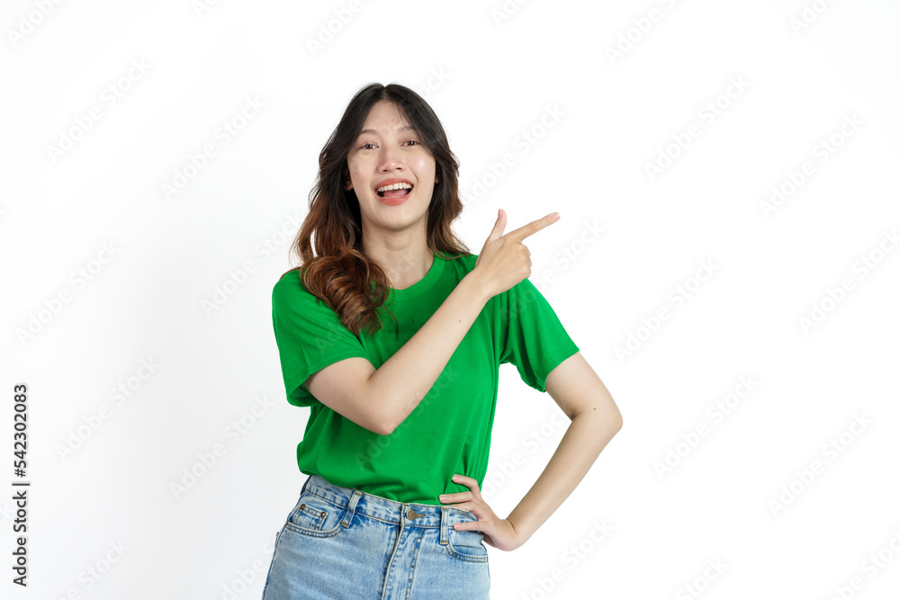 Beautiful confident Asian woman in green empty t-shirt isolated on white background. Point your finger to copy space to introduce products or services Beautiful confident Asian woman in green empty t-shirt isolated on white background. Point your finger to copy space to introduce products or services