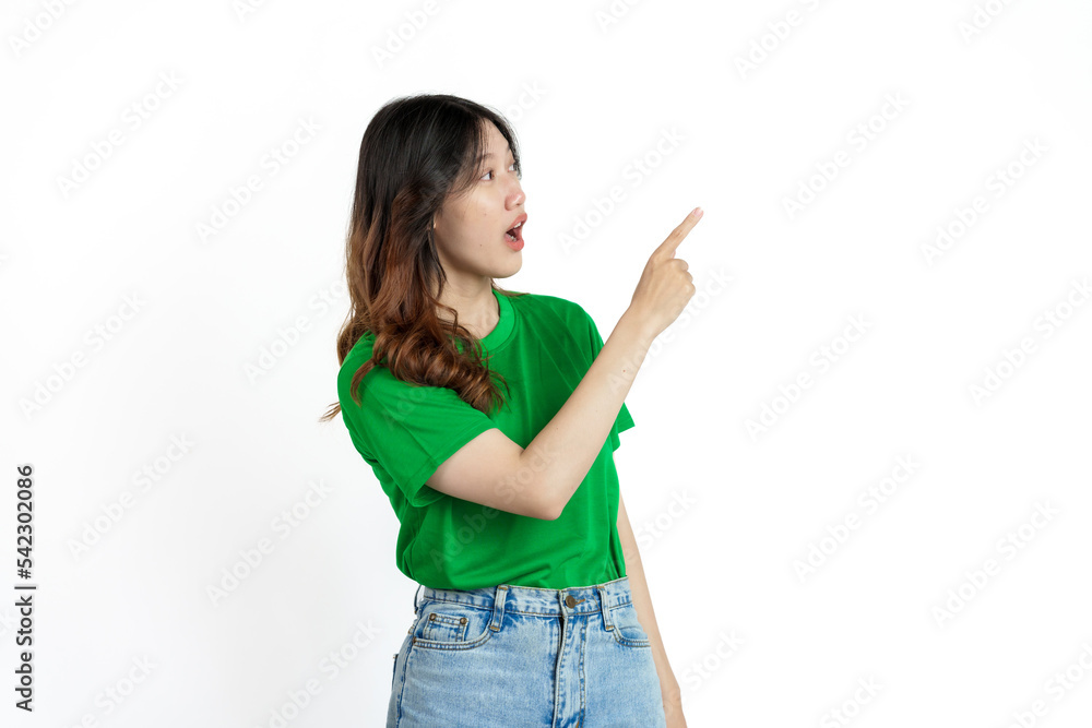 Beautiful confident Asian woman in green empty t-shirt isolated on white background. Point your finger to copy space to introduce products or services Beautiful confident Asian woman in green empty t-shirt isolated on white background. Point your finger to copy space to introduce products or services