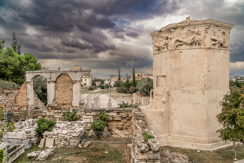 Main street of the Roman Forum of Athens with marble columns, octagonal tower, stormy sky