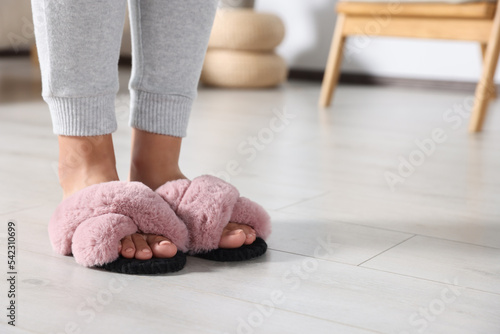 Woman wearing soft slippers at home, closeup of legs