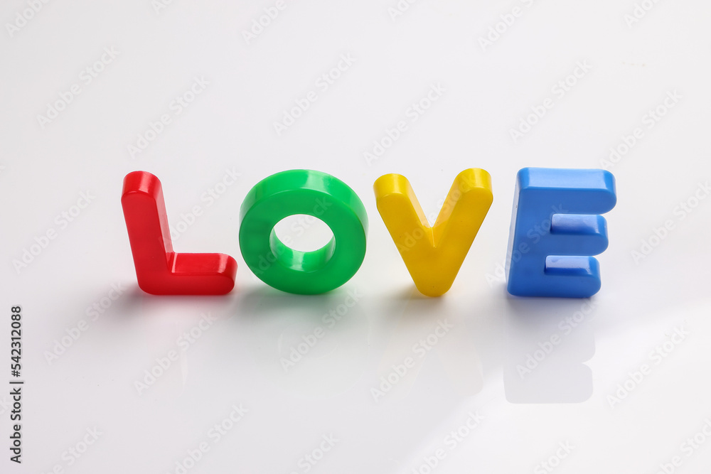 red green blue yellow plastic toy capital font letter alphabet love on white background copy text space concept red green blue yellow plastic toy capital font letter alphabet love on white background copy text space concept