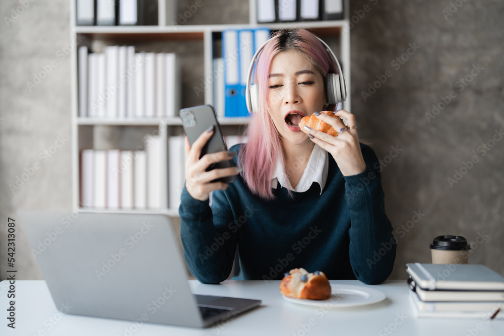 © itchaznong - Young excited asian woman wearing headphone is playing with his smart phone. Gamer with internet © itchaznong - Young excited asian woman wearing headphone is playing with his smart phone. Gamer with internet