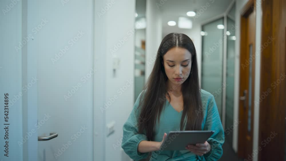 Woman ceo browsing tablet computer in office. Manager walking through corridor Woman ceo browsing tablet computer in office. Manager walking through corridor