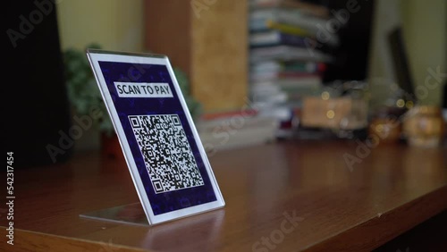 Pay touch-free with a QR code. QR code scanning app. Touchless digital payment option for businesses. A man sits in an open cafe on the beach photo