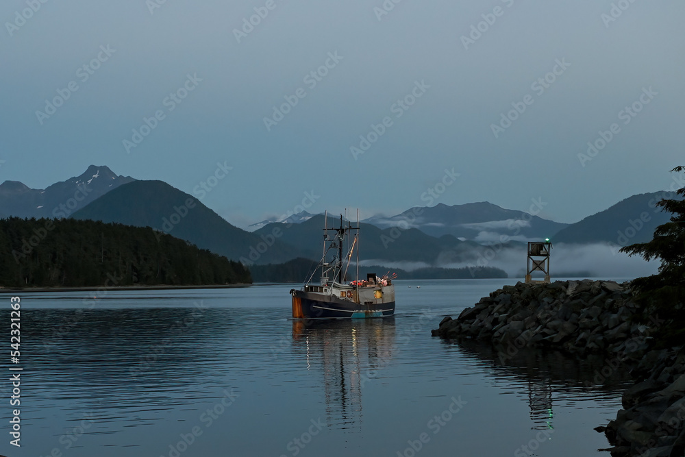 A fishing boat returns to Sitka, Alaska's, Crescent Harbor at dusk.
