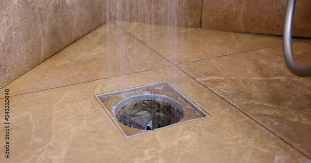 Handyman changes white pipe in bathroom tiled floor for having better