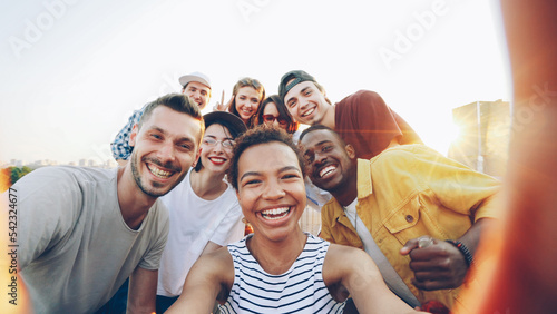Canvas Print Point of view shot of pretty African American girl holding camera and taking selfie with happy friends at party on roof
