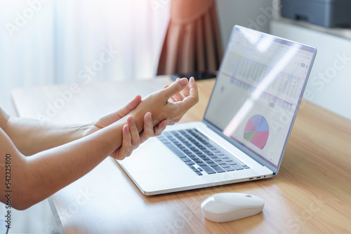 Woman having wrist pain when using mouse during working long time on workplace. De Quervain s tenosynovitis, ergonomic, Carpal Tunnel Syndrome or Office syndrome concept photo