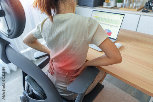 Papier peint Woman having back body pain during work long time on workplace