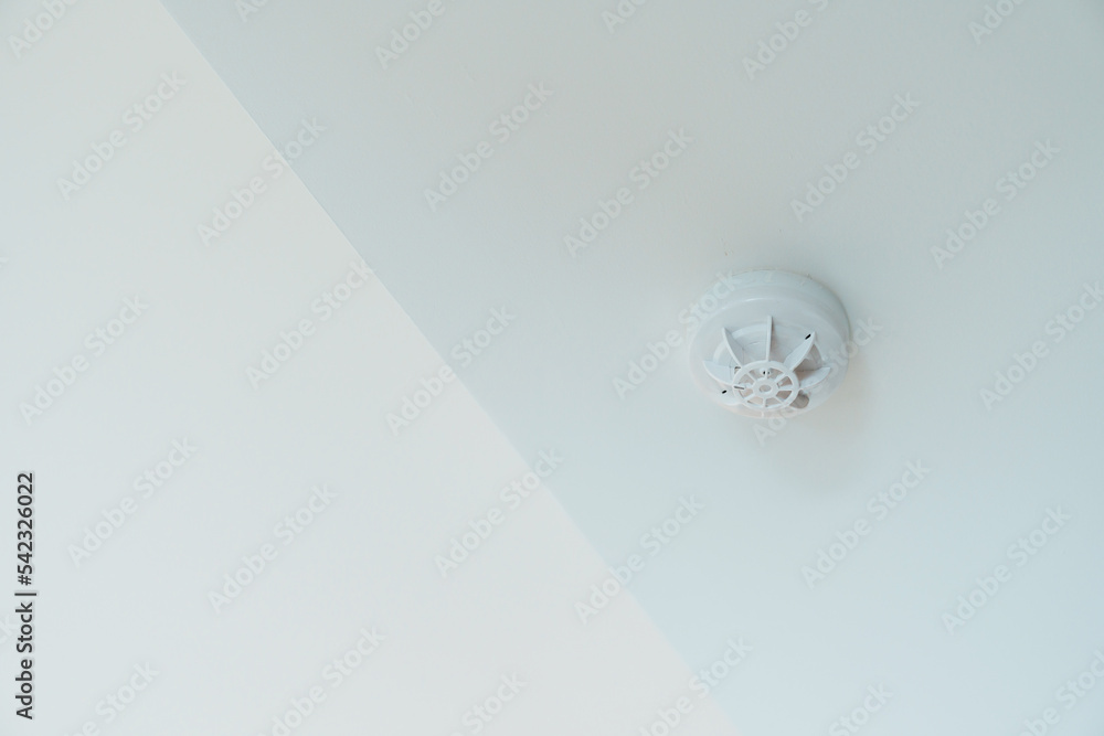 Smoke sensor detector mounted on roof in home or apartment. Safety and conflagration security concept Smoke sensor detector mounted on roof in home or apartment. Safety and conflagration security concept