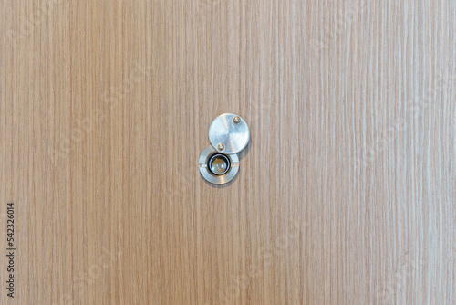 Lens peephole on wood door in apartment room. Security concept photo