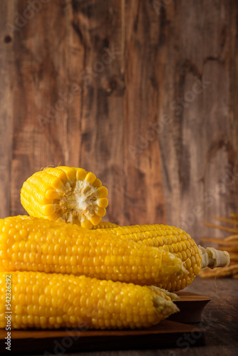 Group of corn cob in tray on wood tabele and wall photo