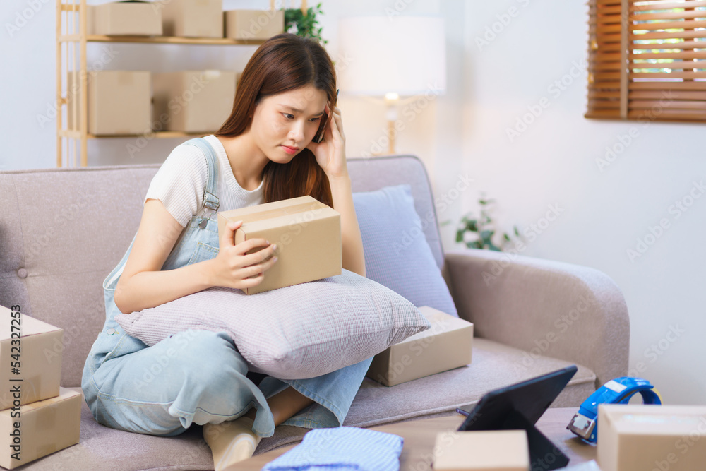 Online merchant concept, Female entrepreneur confused while reading data on tablet to write address Online merchant concept, Female entrepreneur confused while reading data on tablet to write address